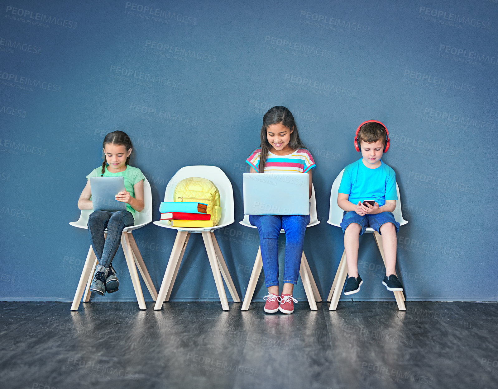 Buy stock photo Chairs, children, and technology for learning and education while online for research on internet. Kids or students against a blue mockup wall with laptop, tablet and video on phone in a waiting room