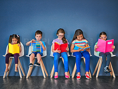 Buy stock photo Education, kids and row with books in studio for knowledge, development and studying for test. Chair, children and students reading with paper for school, scholarship and learning for academic growth