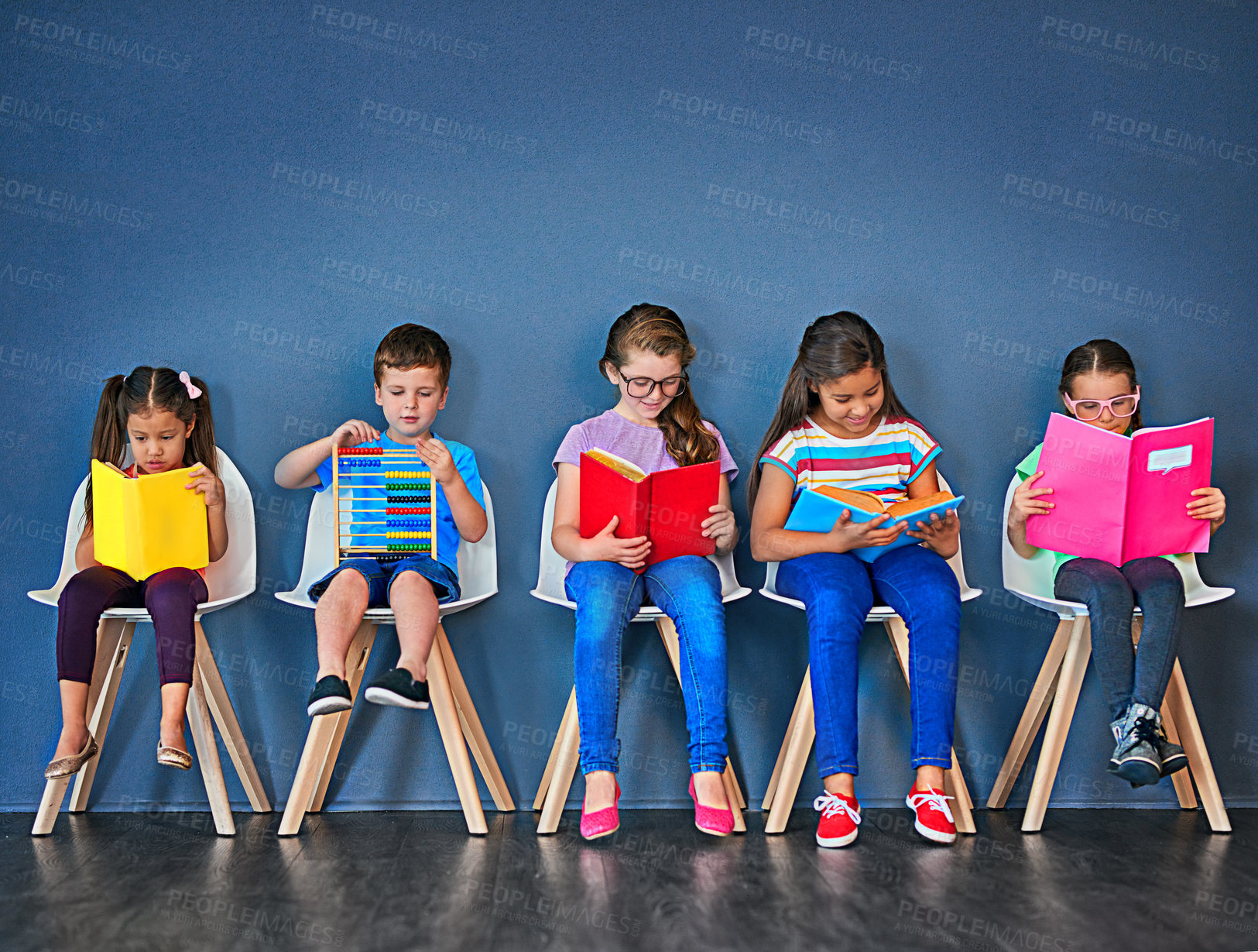 Buy stock photo Education, kids and row with books in studio for knowledge, development and studying for test. Chair, children and students reading with paper for school, scholarship and learning for academic growth