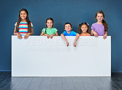 Buy stock photo Children, smile and portrait in studio for placard, advertising and marketing with mockup space. People, happy and face on blue background for banner, branding and presentation with logo information