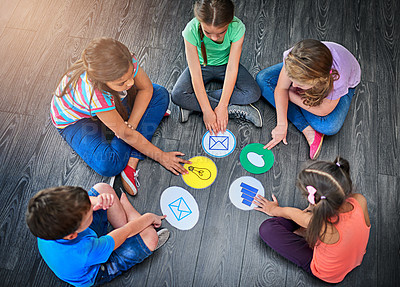 Buy stock photo Children, group and playing a game on floor with communication icons, decision making and learning. Diversity, people and problem solving with educational activity, solution or knowledge on top view