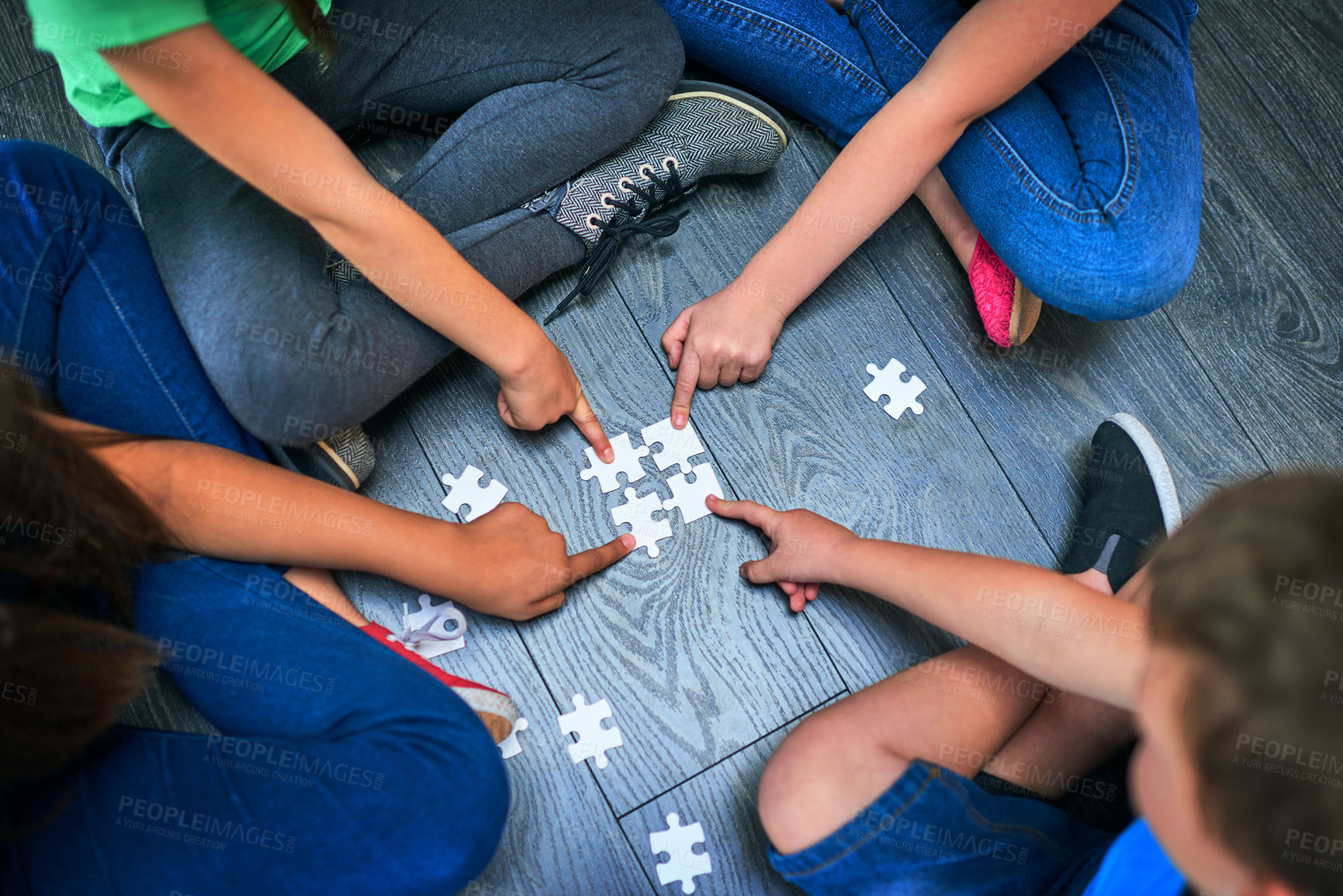 Buy stock photo Above, children and hands with puzzle for game, cognitive development and solution skills by floor. Teamwork, kids and solidarity with jigsaw for problem solving, decision and friends for playing