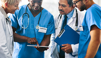 Buy stock photo Group of doctors, medical professionals and workers doing reaching on a tablet, browsing on the internet and discussing a health case together at a hospital. Experts talking about a diagnosis