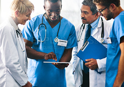 Buy stock photo Shot of a team of doctors using a digital tablet together in a hospital