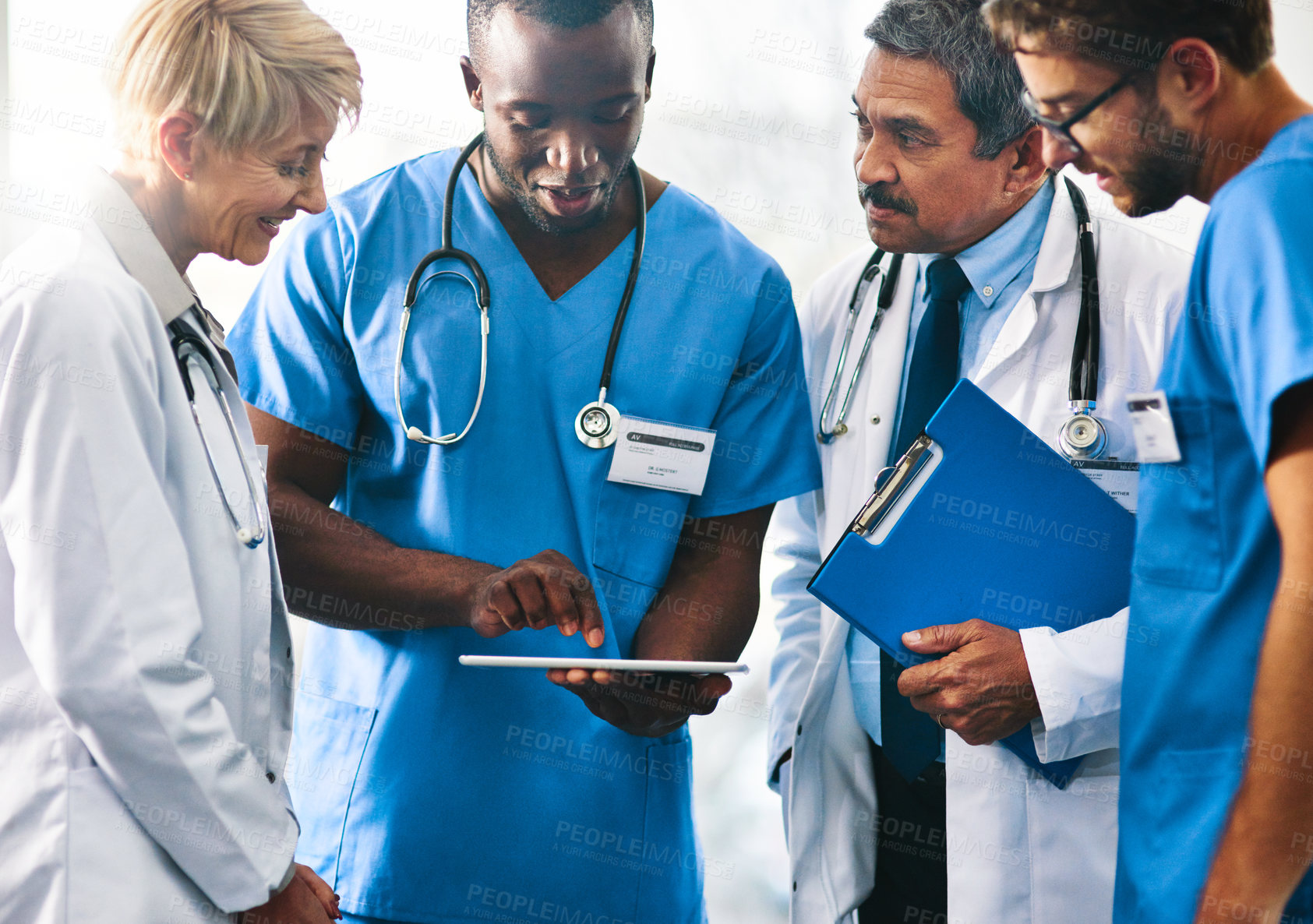 Buy stock photo Shot of a team of doctors using a digital tablet together in a hospital