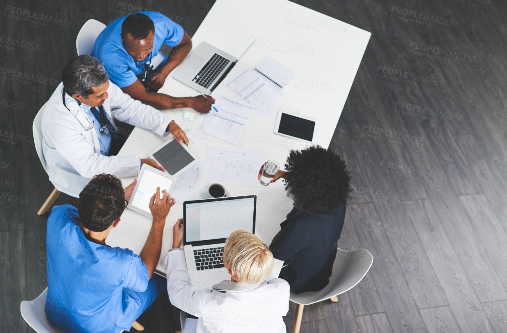 Buy stock photo High angle shot of a team of doctors having a meeting in a hospital