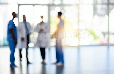 Buy stock photo Blurred shot of a team of doctors standing together in a hospital