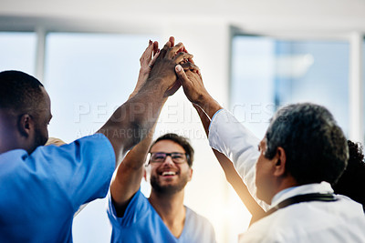 Buy stock photo Doctors celebrating medical success after working together as a team and give each other motivating a high five as a group in a hospital. Healthcare workers joining hands in a huddle showing teamwork