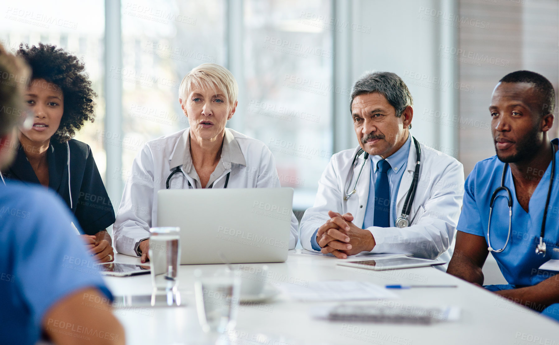 Buy stock photo Shot of a team of doctors having a meeting in a hospital