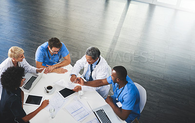 Buy stock photo High angle shot of a team of doctors having a meeting in a hospital