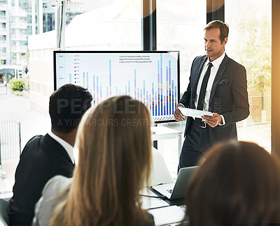 Buy stock photo Shot of a businessman using a digital tablet while doing a presentation