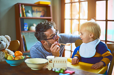 Buy stock photo Cropped shot of a single father feeding his son at home