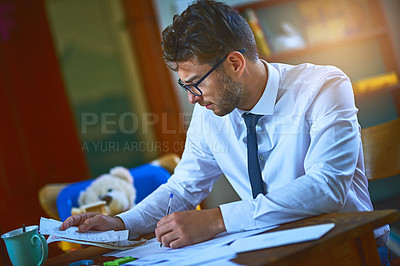 Buy stock photo Cropped shot of a single father paying his bills at home