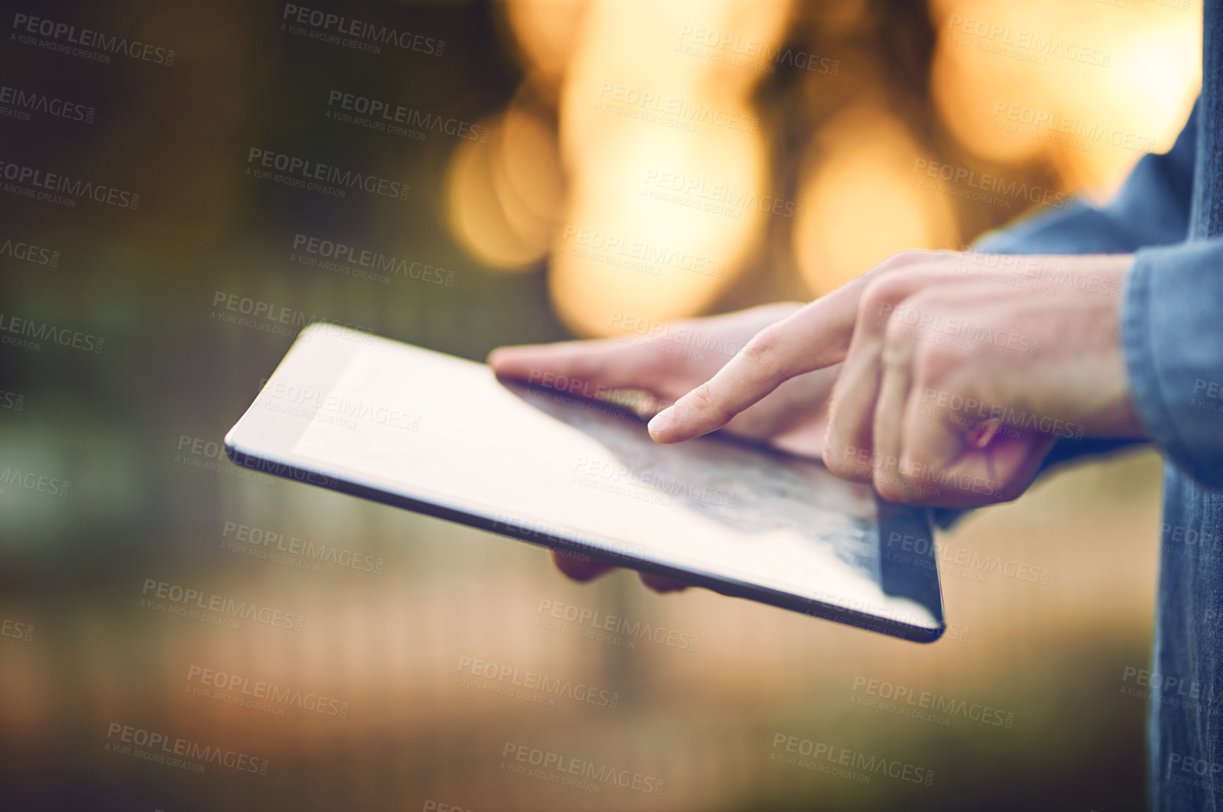 Buy stock photo Cropped shot of an unrecognizable man using a tablet outdoors