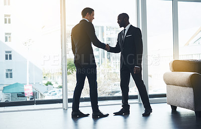 Buy stock photo Shot of two businessmen shaking hands in an office