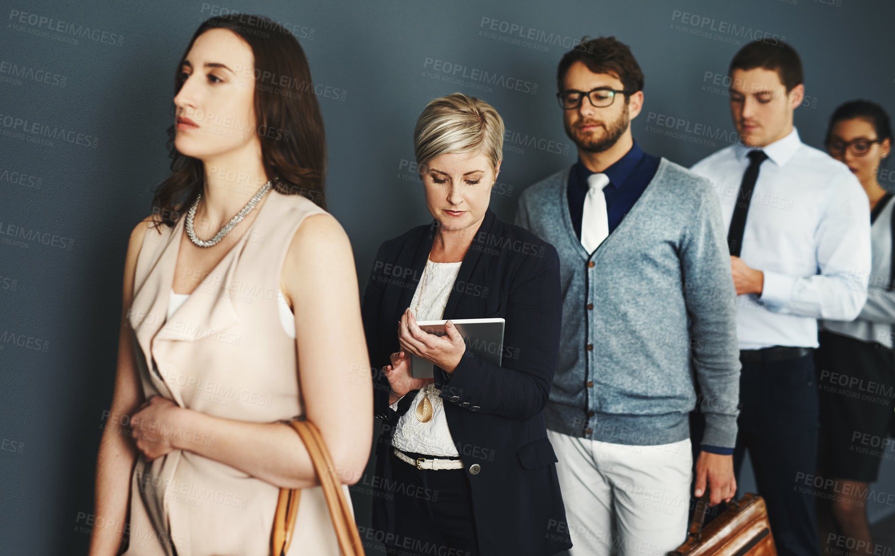 Buy stock photo Studio shot of a group of businesspeople waiting in line against a grey background