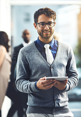 Buy stock photo Portrait of a young businessman using a digital tablet in a busy office