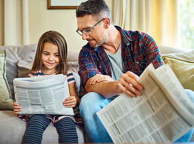 Buy stock photo Cropped shot of a handsome mature man and his daughter reading the morning paper