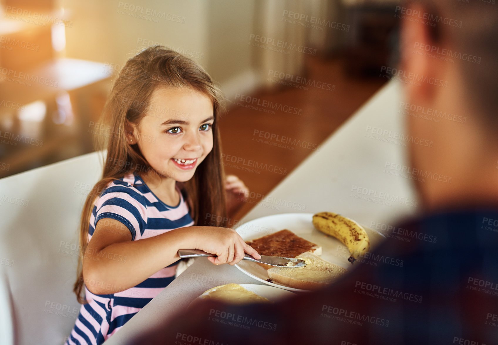 Buy stock photo Cropped shot of an adorable little girl having breakfast with her father in the kitchen