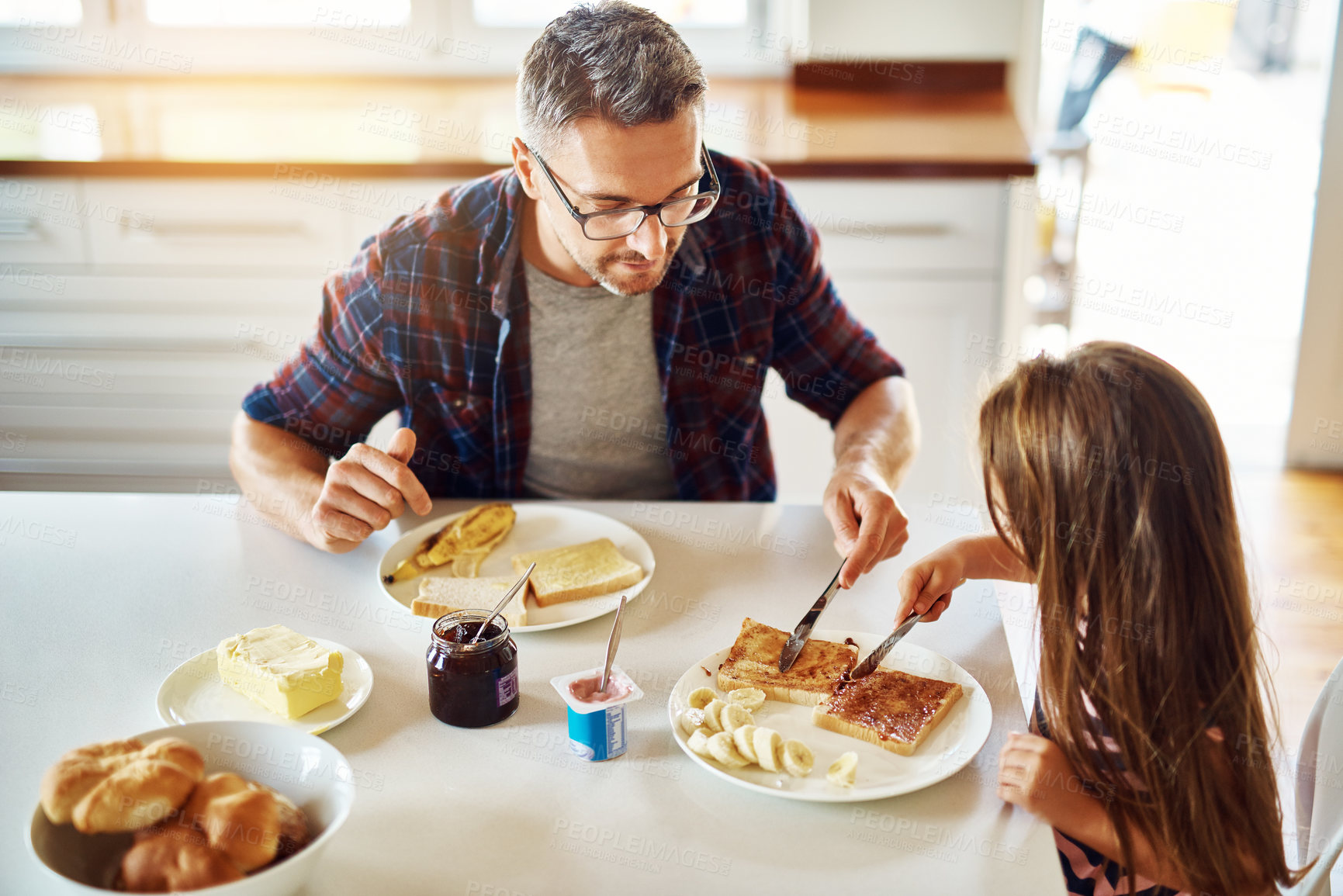 Buy stock photo Cropped shot of an adorable little girl having breakfast with her father in the kitchen
