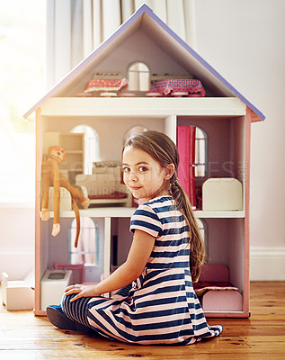 Buy stock photo Rearview shot of a little girl playing with her dollhouse while sitting on her bedroom floor