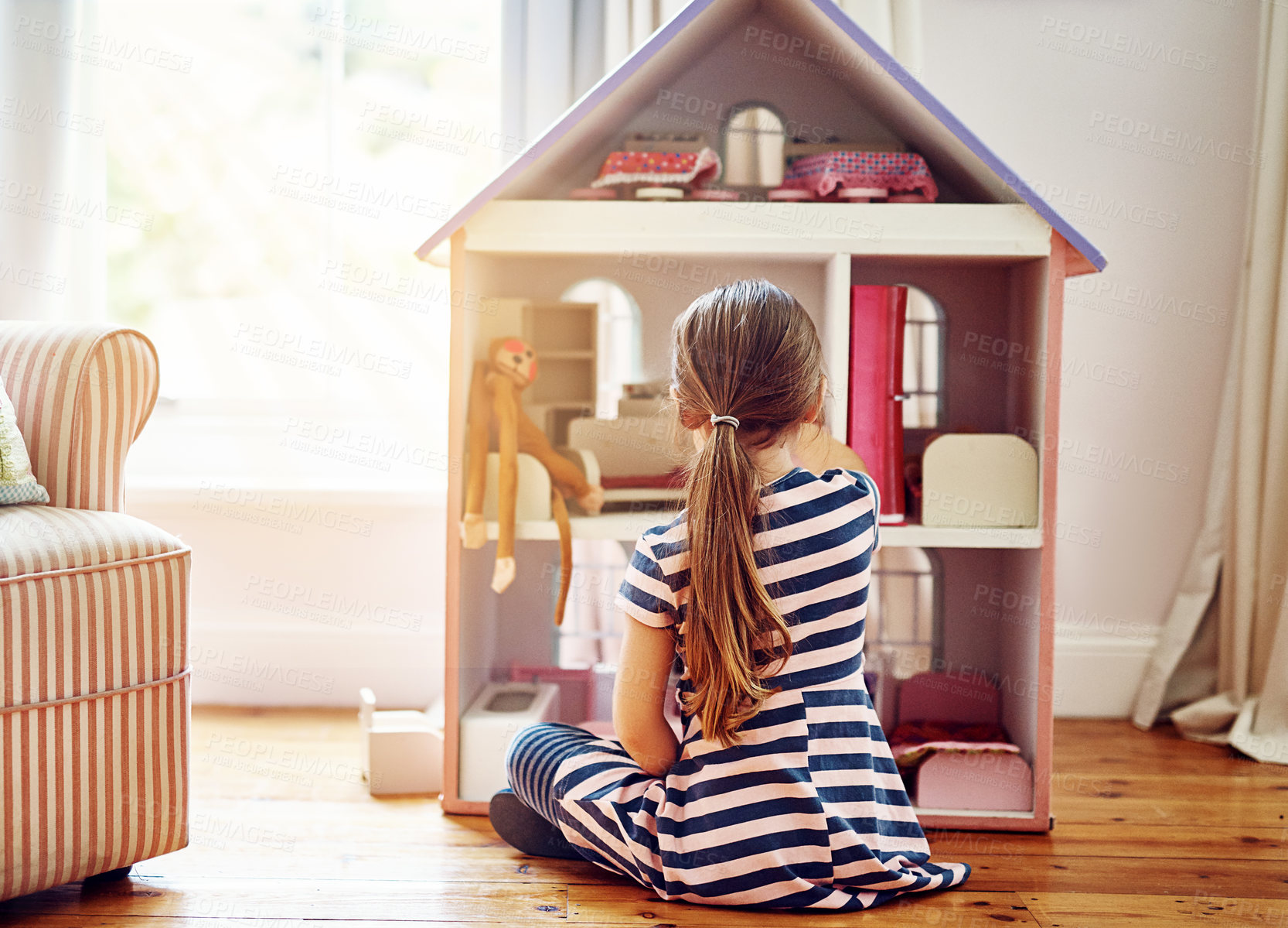 Buy stock photo Dollhouse, home and child play with fun game, imagination and dream on floor in living room alone. Kid from back with tiny furniture for story development, cognitive and creative learning with toys