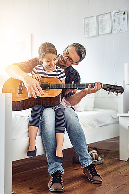 Buy stock photo Full length shot of a handsome mature man teaching his young daughter how to play the guitar