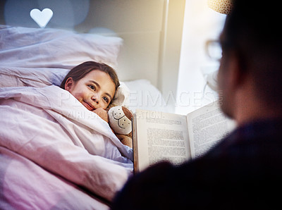 Buy stock photo Cropped shot of a father reading his young daughter a bedtime story