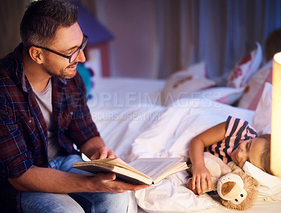 Buy stock photo Cropped shot of a father reading his young daughter a bedtime story