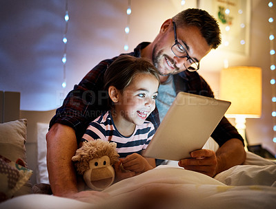 Buy stock photo Cropped shot of a father reading his young daughter a bedtime story on a tablet