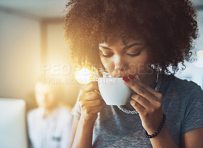 Buy stock photo Shot of a young businesswoman enjoying a cup of coffee while standing in the office
