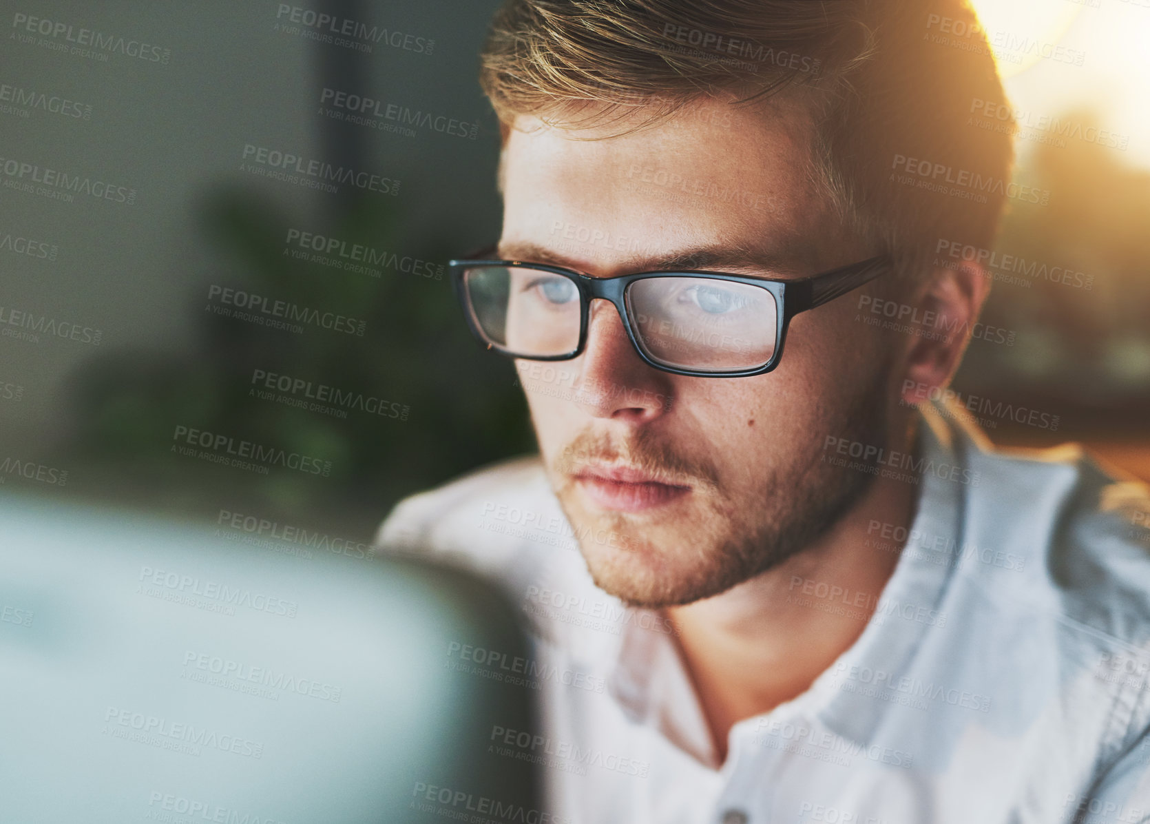 Buy stock photo Shot of a young designer working on a computer while wearing glasses in the office
