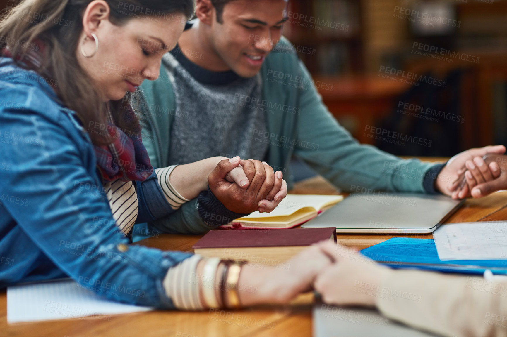 Buy stock photo Closeup shot of an unidentifiable group of university students holding hands in prayer