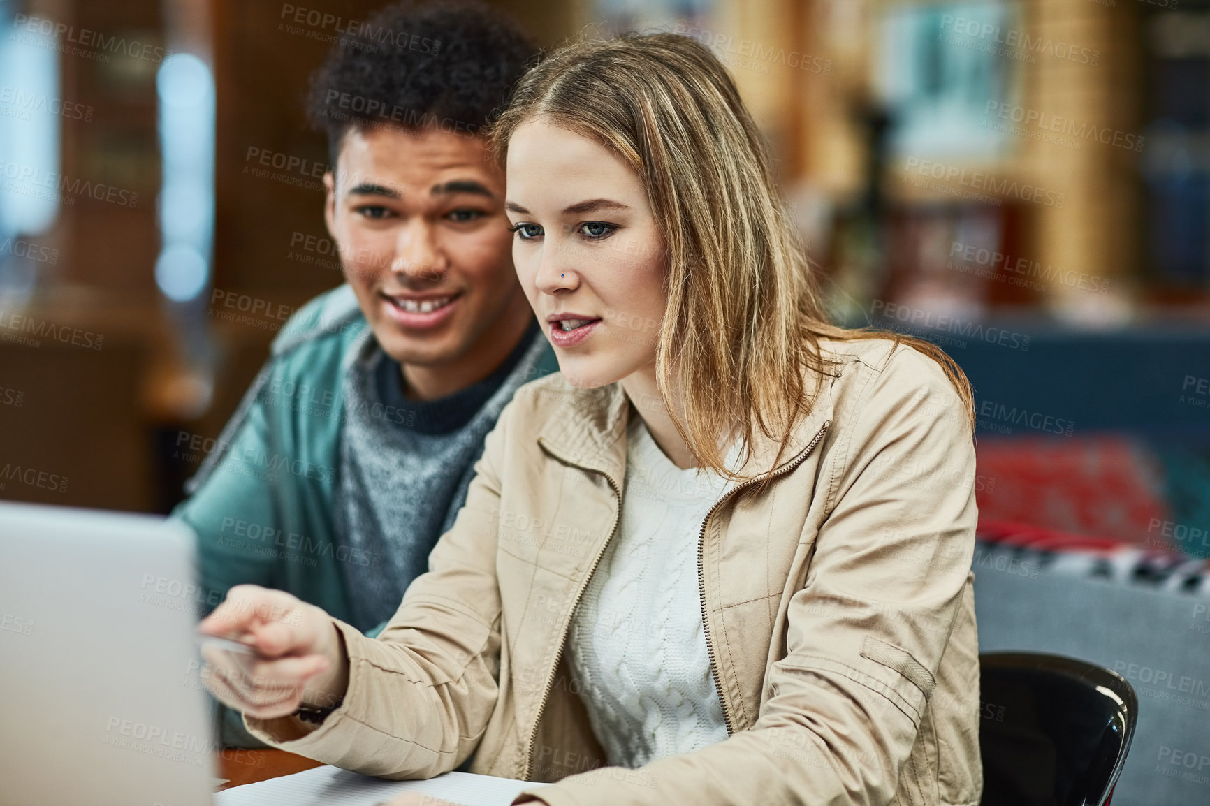 Buy stock photo Shot of two university students working together on a laptop at campus