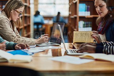 Buy stock photo Shot of a group of university students working in the library at campus