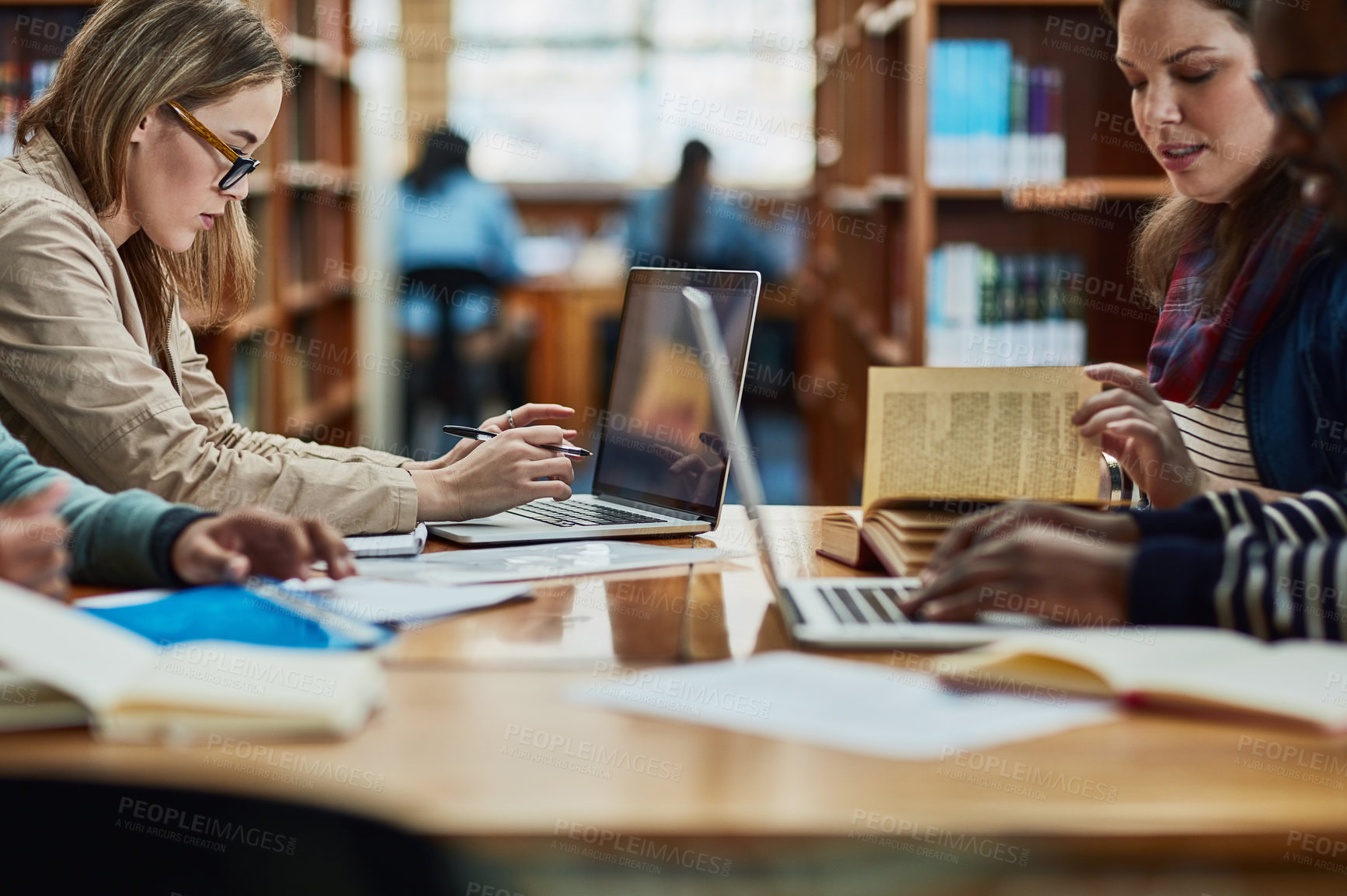 Buy stock photo Shot of a group of university students working in the library at campus