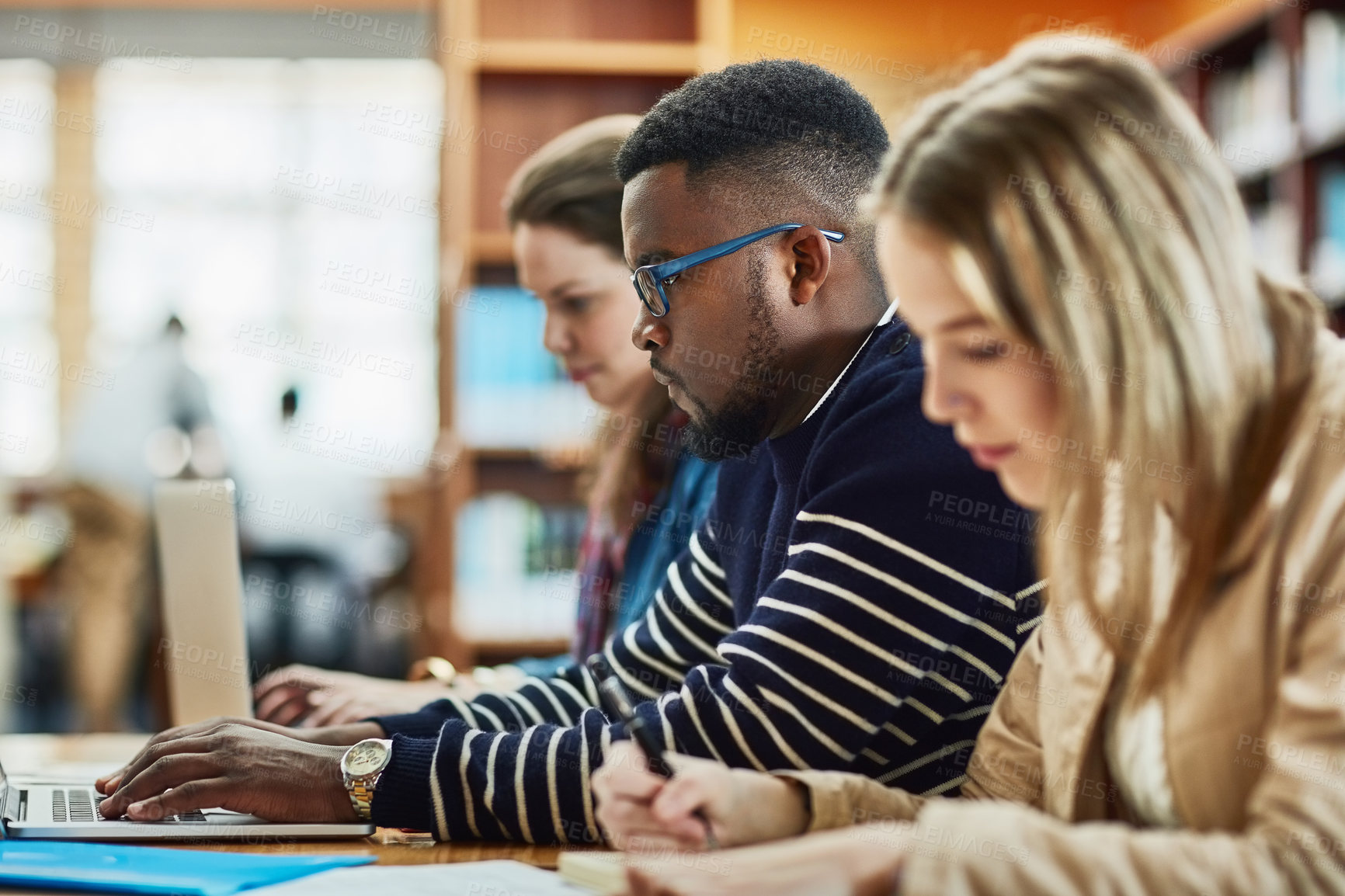 Buy stock photo Shot of a group of university students sitting in class at campus