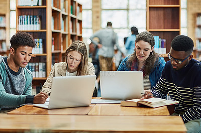 Buy stock photo Shot of a group of university students working in the library at campus