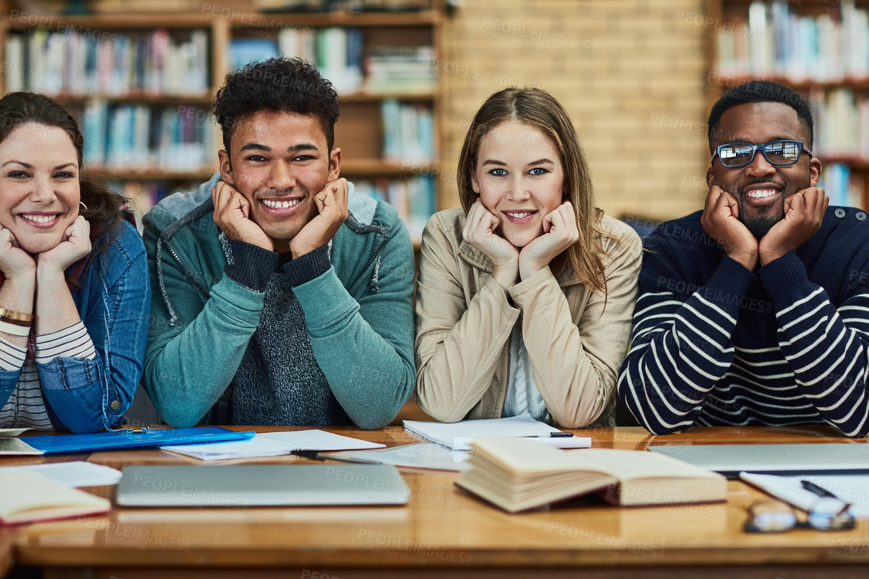 Buy stock photo Portrait of a group of university students sitting in the library at campus