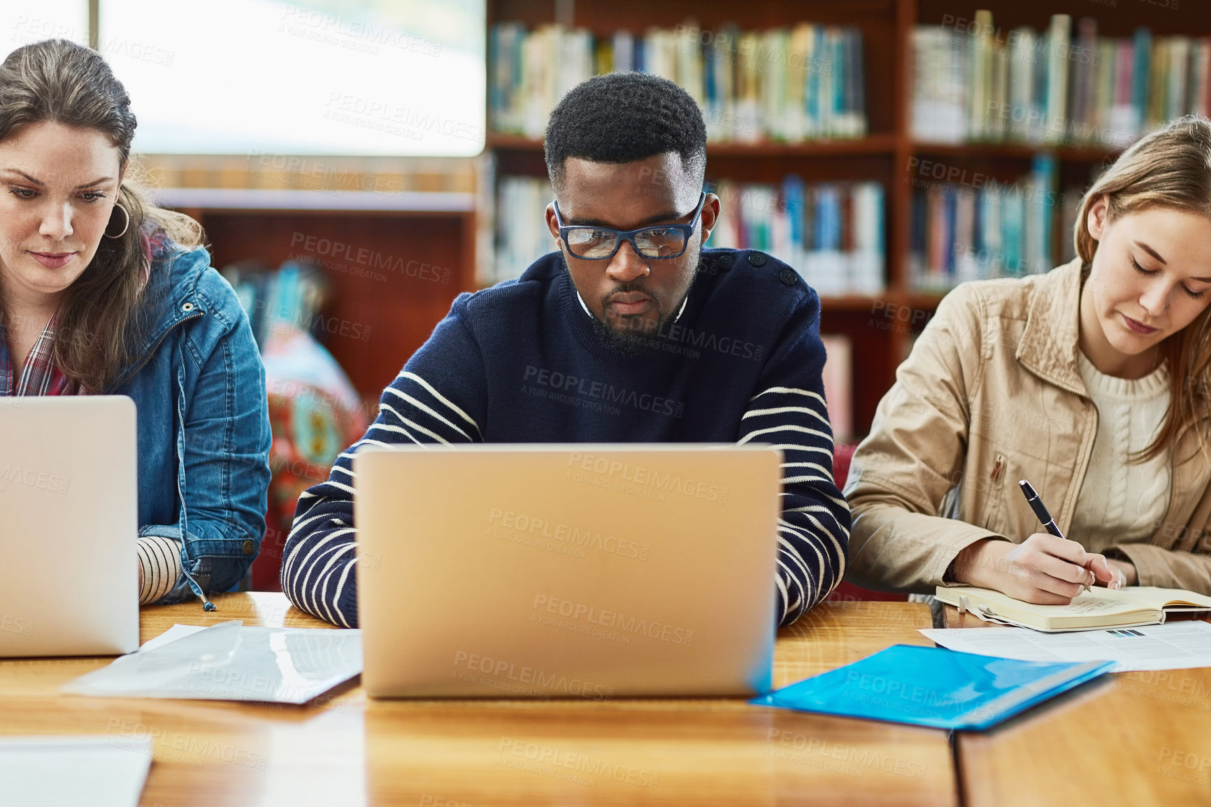 Buy stock photo Laptop, research and man learning at library for education, knowledge or test preparation in college. University students, friends and studying on computer for help, project notes and online report