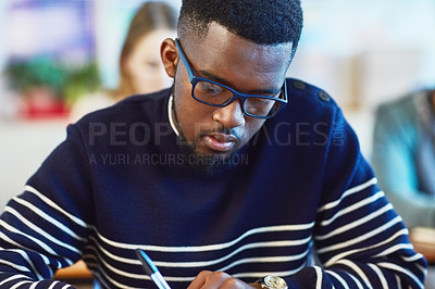 Buy stock photo Shot of a university student working in class at campus