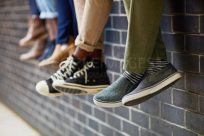 Buy stock photo Brick wall, students feet and friends outdoor on university campus together with sneakers. Relax, youth and foot at college with people legs ready for education, study and urban shoes while sitting
