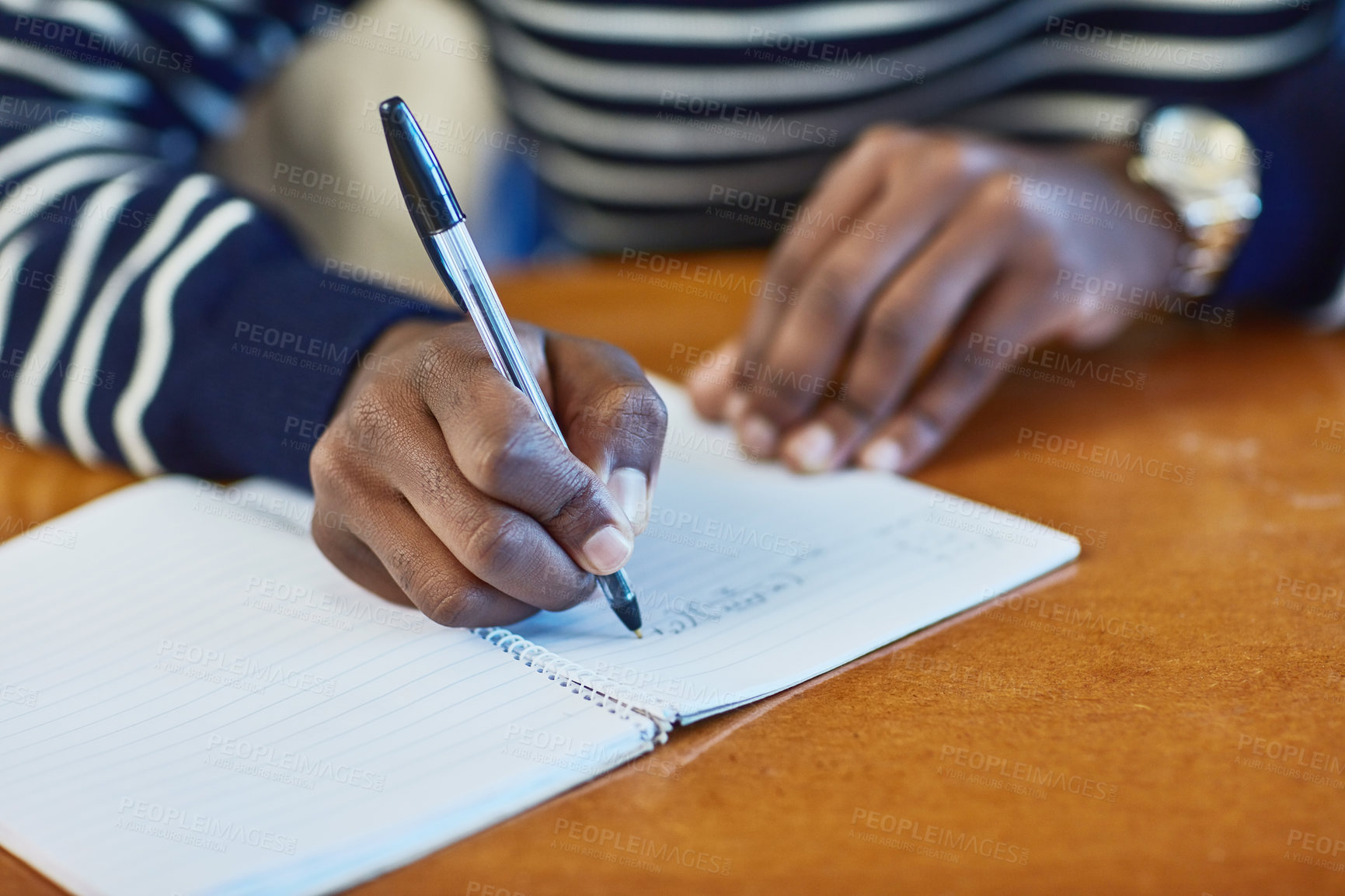 Buy stock photo Closeup shot of an unidentifiable university student writing in a book at campus