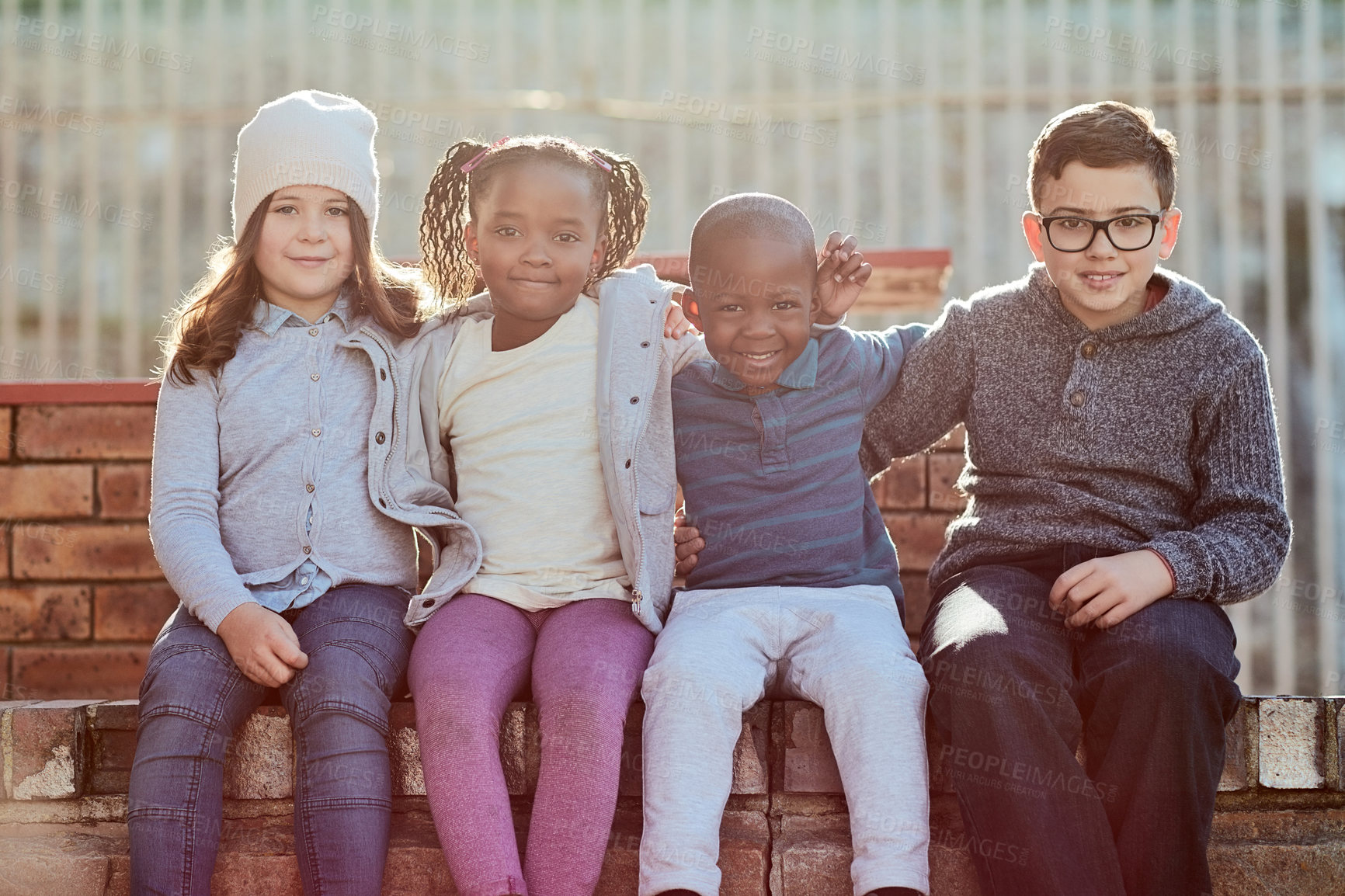 Buy stock photo Children,  portrait and hug at outdoor school, students and break for learning development on wall. Kids, embrace and group together for elementary knowledge, education and pupils for kindergarten