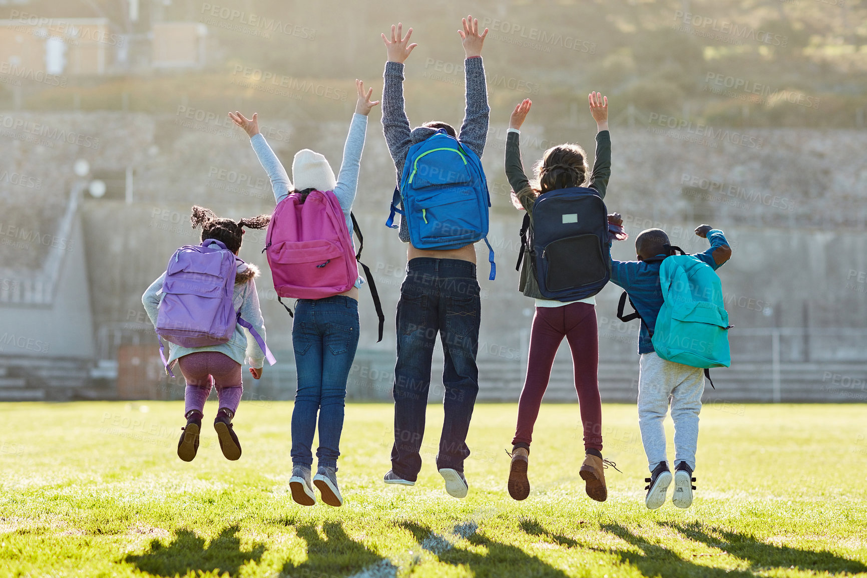 Buy stock photo Rearview shot of elementary school kids jumping outside