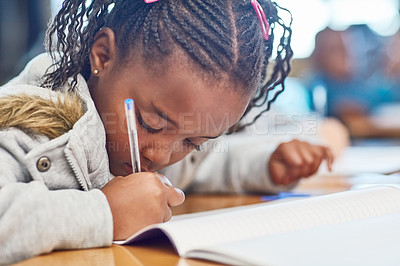 Buy stock photo Cropped shot of an elementary school girl doing school work in the classroom