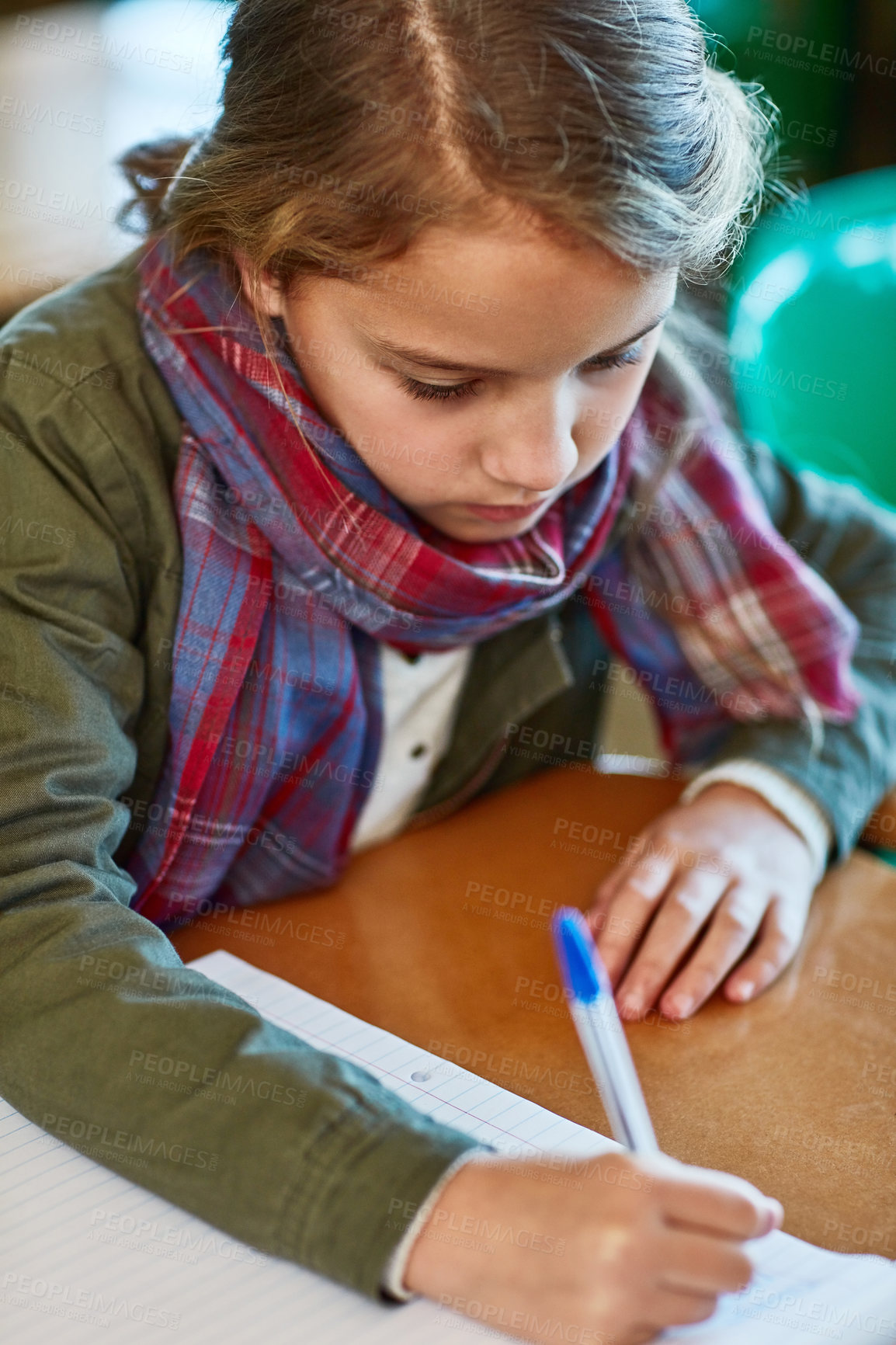 Buy stock photo Cropped shot of an elementary school girl doing her school work in the classroom