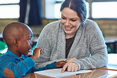 Buy stock photo Cropped shot of an elementary school boy getting help from his teacher in the classroom