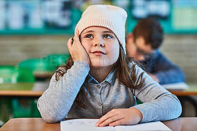 Buy stock photo Cropped shot of an elementary school girl daydreaming in the classroom
