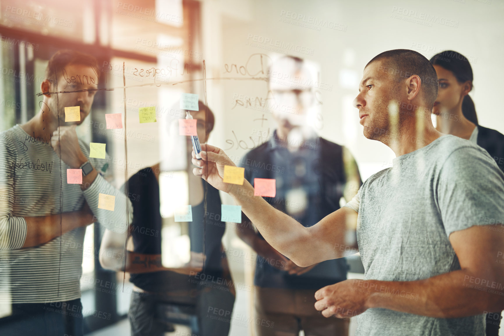 Buy stock photo Cropped shot of a group of young designers using sticky notes during a brainstorming session